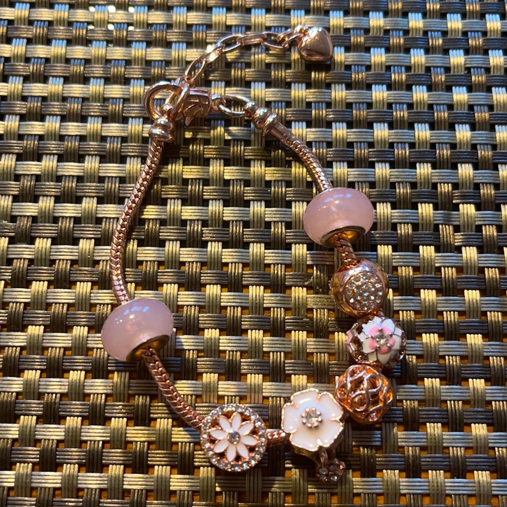 Rose gold bracelet with beautiful floral charms. Super chic.
